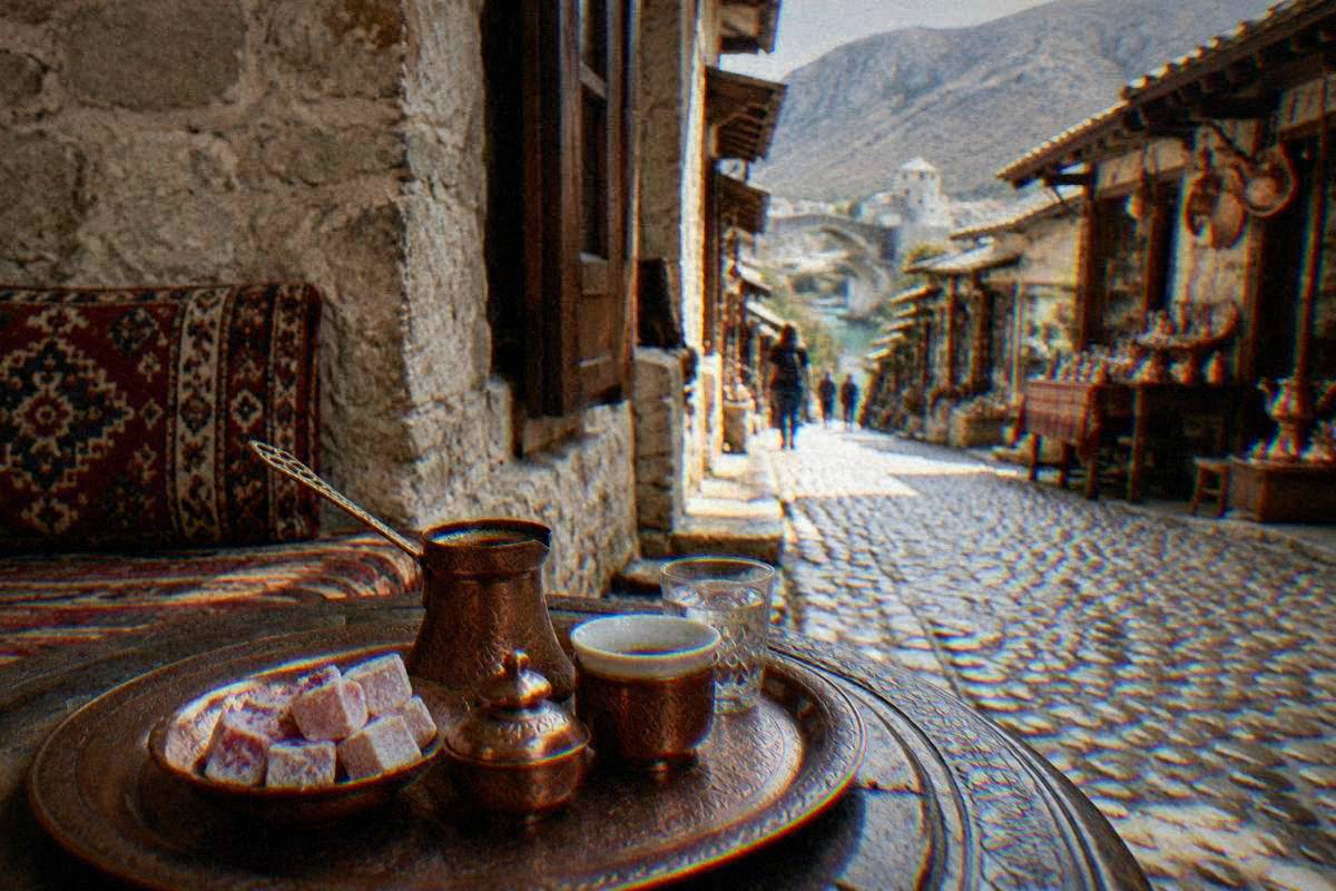A copper Bosnian coffee set, small cups and rose-water sweets on a low table in a stone-walled room in Kujundziluk, Mostar