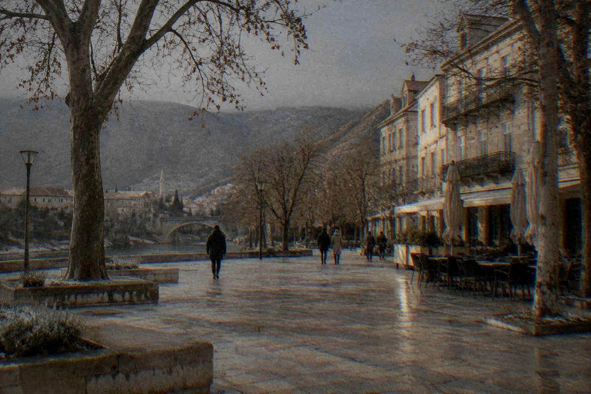 Musala Square in Mostar on a cold winter morning, bare plane trees, grey sky and tall balconied buildings, a scattering of frost, Trg Musala