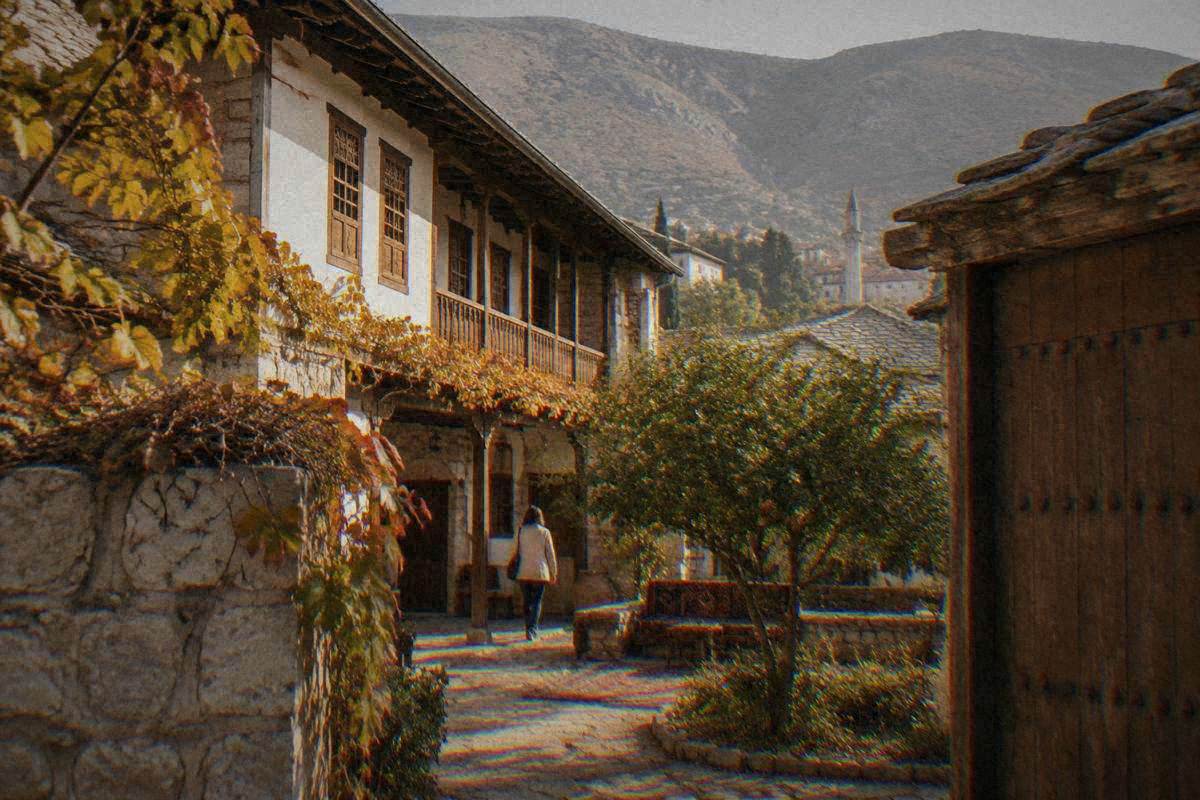 An Ottoman house of stone and white plaster with a timber upper floor and a walled courtyard in Mostar, an Ottoman house with a wooden gallery around a walled courtyard, Biscevic House