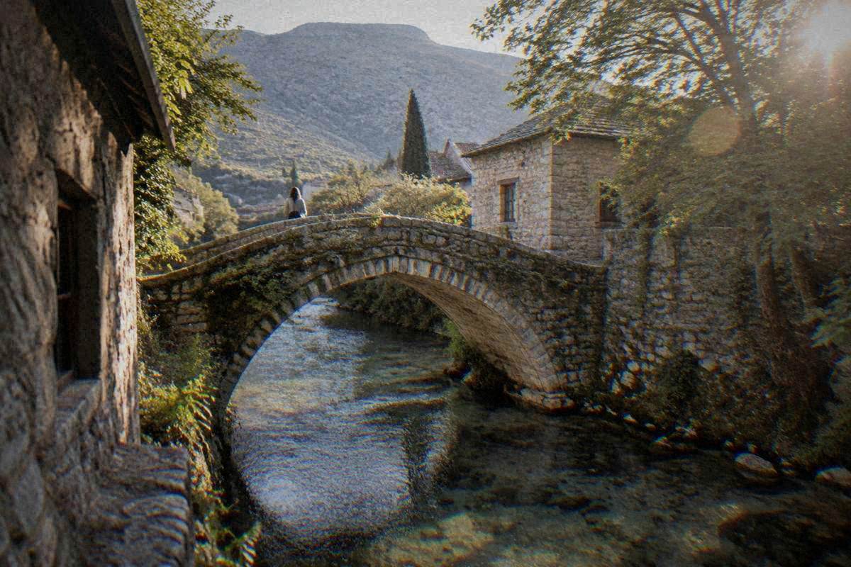 The Crooked Bridge (Kriva cuprija) in Mostar, a small single-arch stone footbridge over a stream with mossy parapets