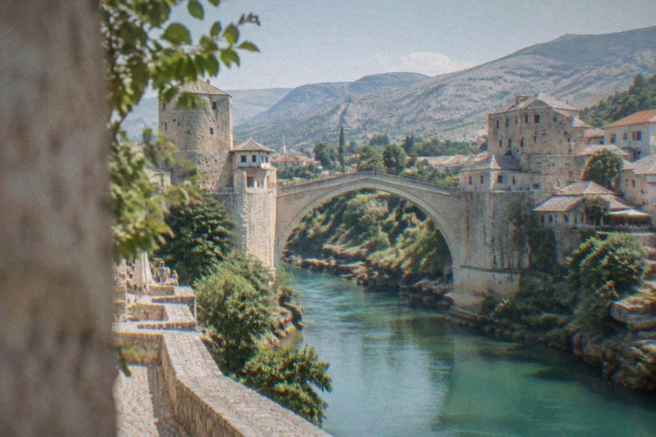 The Old Bridge in Mostar lit up after dark above the Neretva river