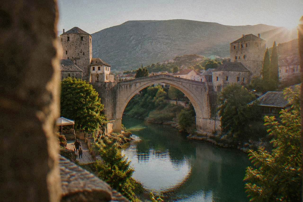 The single stone arch of Stari Most crossing the green Neretva river at golden hour