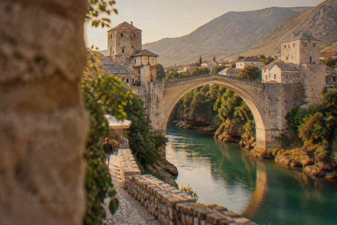 The stone arch of the Old Bridge spanning the green Neretva river in Mostar