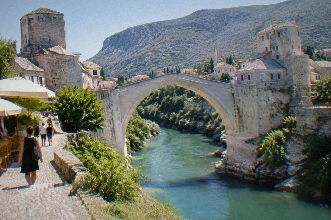 The single stone arch of the Old Bridge spanning the green Neretva river in Mostar