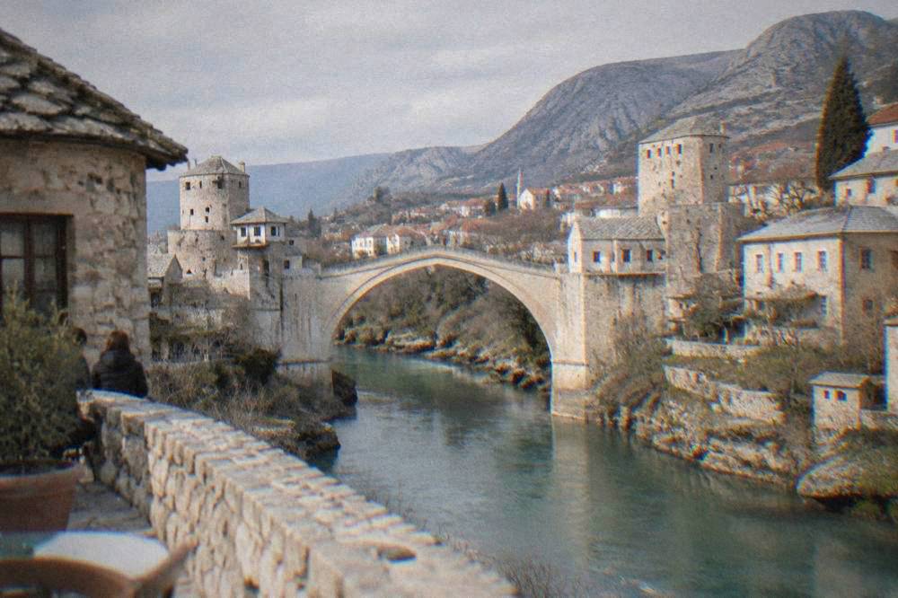 Stone terrace overlooking the Neretva with the arch of the Old Bridge framed between buildings
