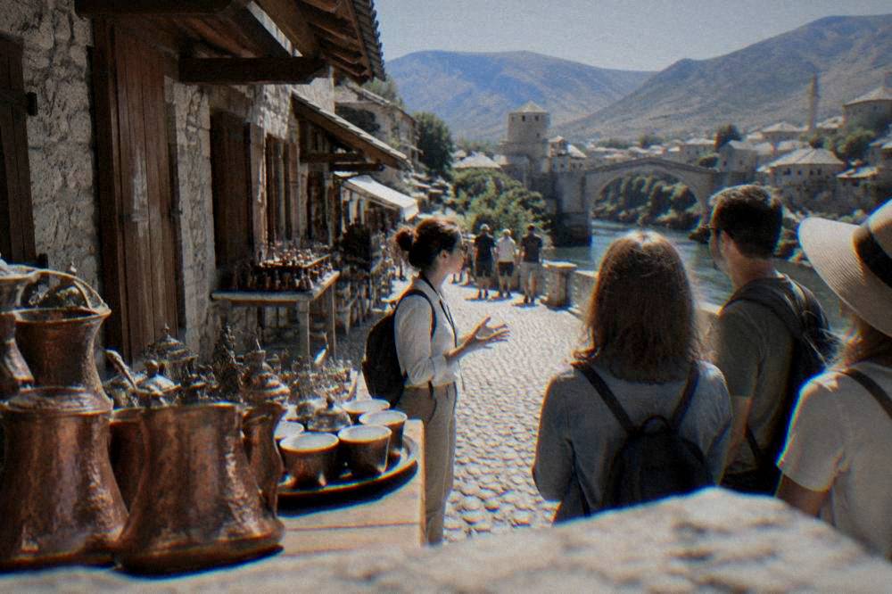 Guide speaking to a small group on a stone lane near the river in Mostar old town