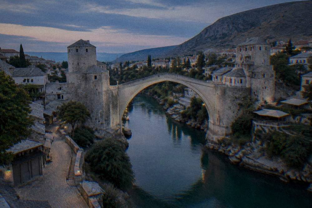The Old Bridge and river in soft evening light with empty lanes and closed shop fronts