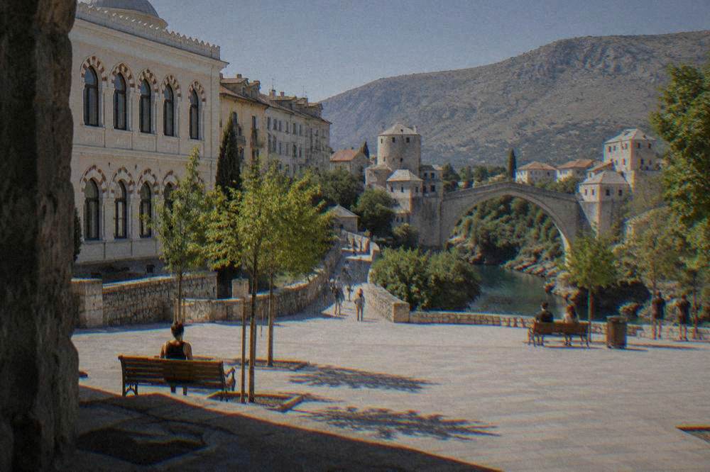A cobbled lane leading from the western bank toward the Old Bridge in Mostar