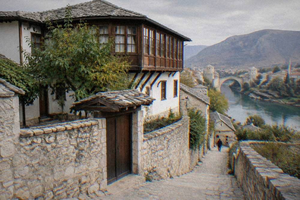 Narrow stone lane leading down toward the Neretva riverbank in the old part of Mostar