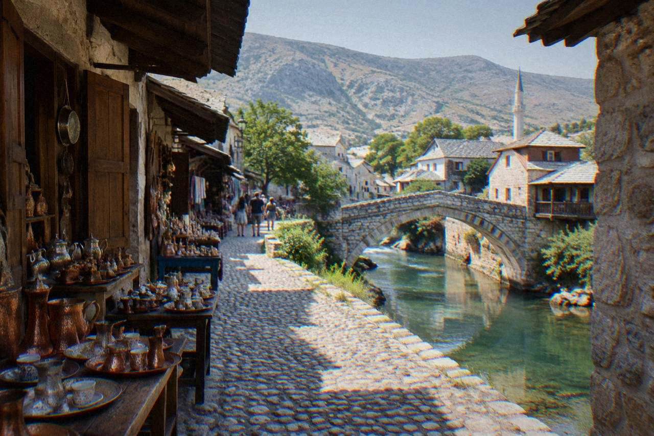 A small stone arch bridge crossing a narrow river between old houses in Mostar
