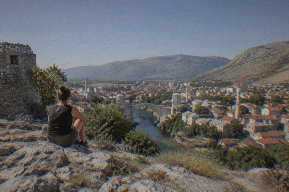Rocky limestone plateau with low vegetation above the city skyline under a clear sky