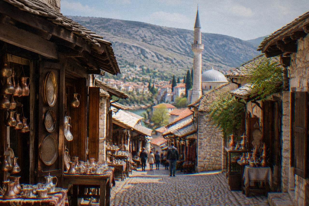 Stone mosque with a tall minaret rising above red-tiled rooftops in Mostar