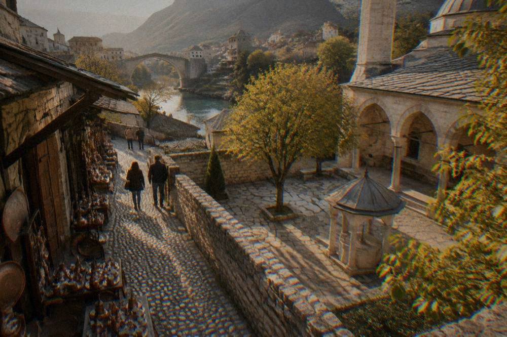 Courtyard of an Ottoman mosque in Mostar with a stone wall and gravestones in shade