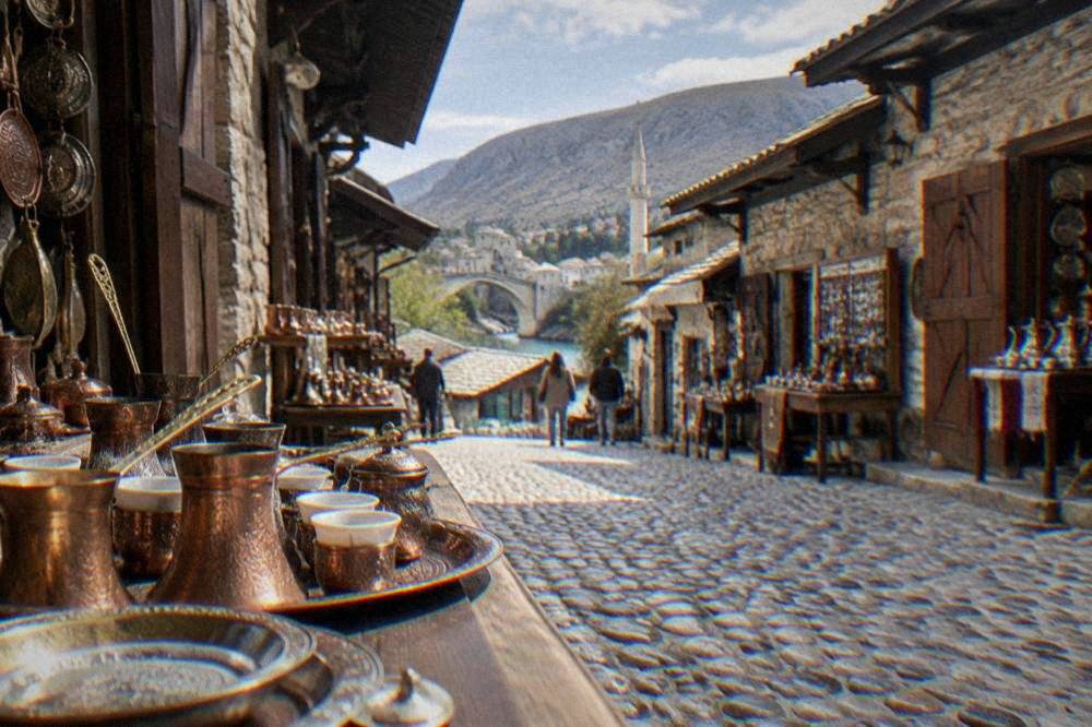 Narrow stone-paved lane in the Mostar Old Bazaar lined with small shops