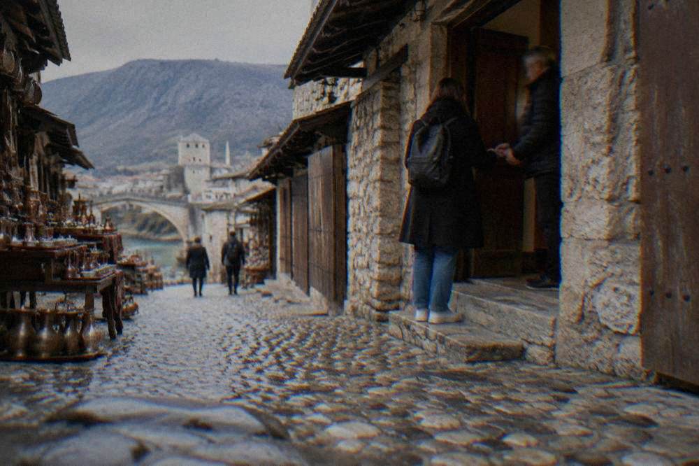 Visitor paying a small cash fee at the entrance of a historic Mostar building