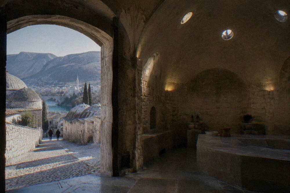 Warm stone room of a Ottoman bathhouse with vaulted ceiling and low light through ceiling openings