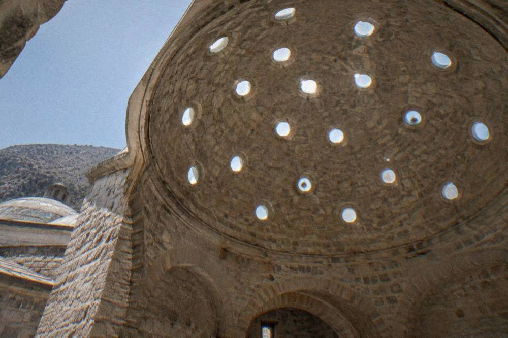 Round glass skylights in a stone dome of an Ottoman bathhouse seen from below