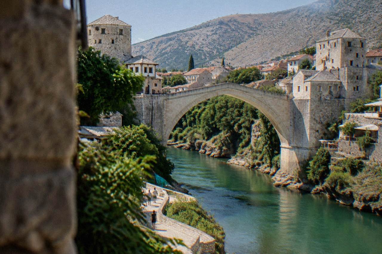 A stone tower beside the arch of Mostar's Old Bridge above the Neretva river