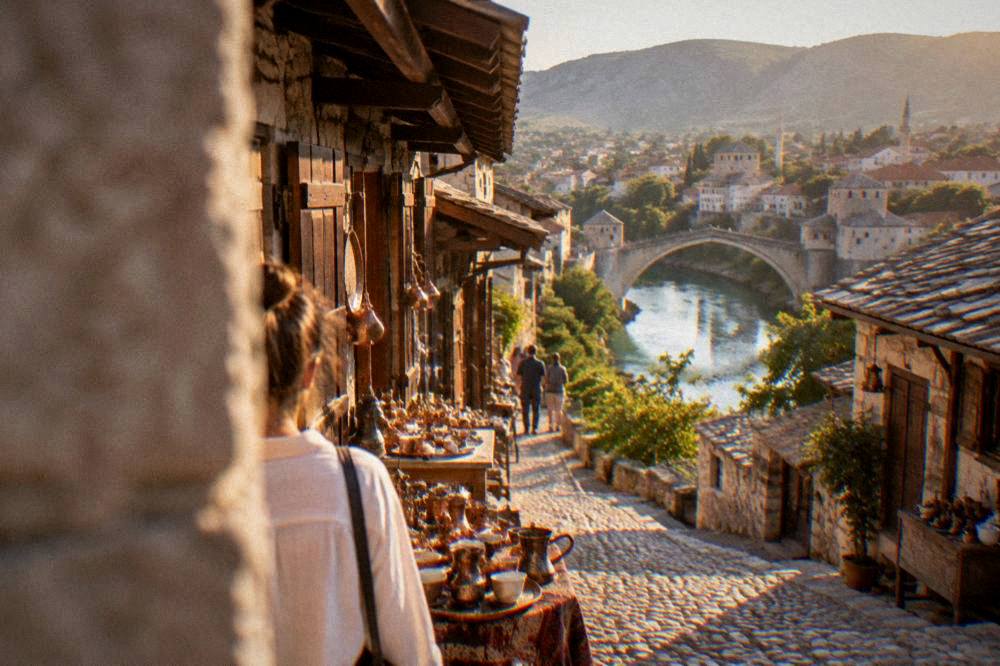 Golden evening light over the terracotta roofs of central Mostar with the Neretva winding through the city