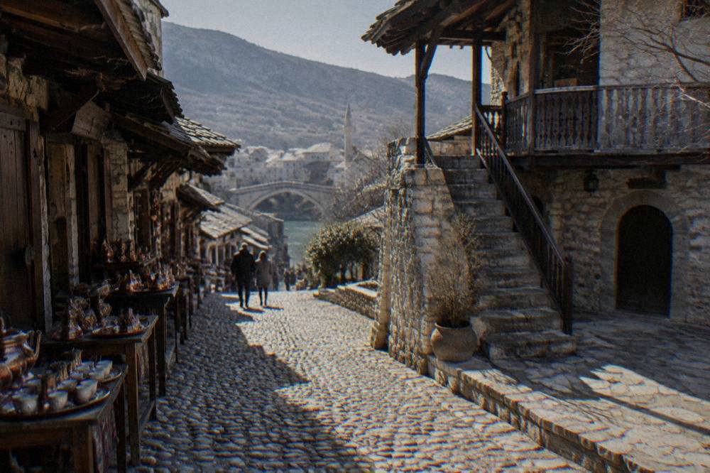 Courtyard of an Ottoman stone house in Mostar with a stone staircase to an upper wooden gallery