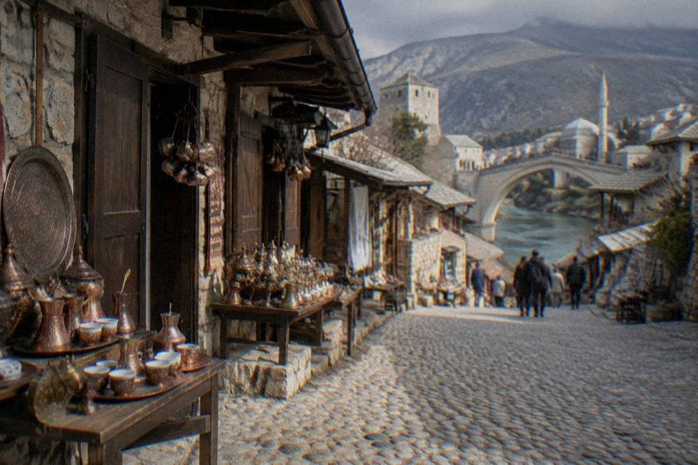 Cafe tables and pedestrians on a sunny boulevard near a central square in Mostar