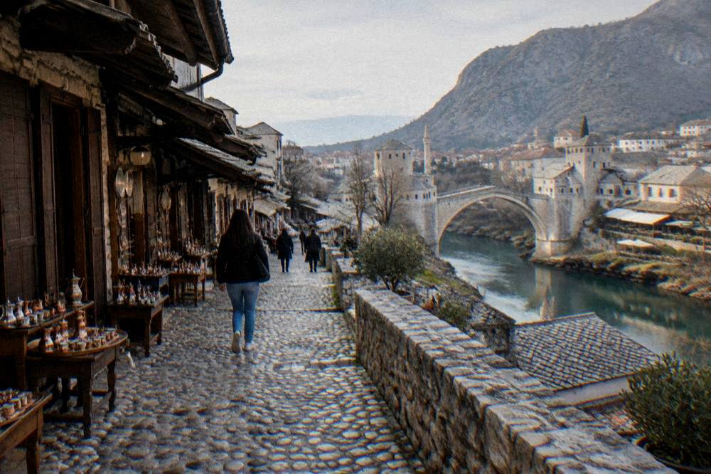 Late afternoon light across a central city square in Mostar with the old town rooftops beyond