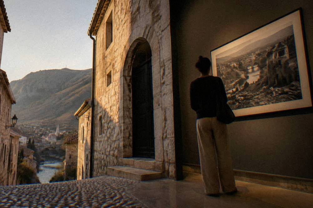 A visitor studying a large framed photograph on a gallery wall in low light