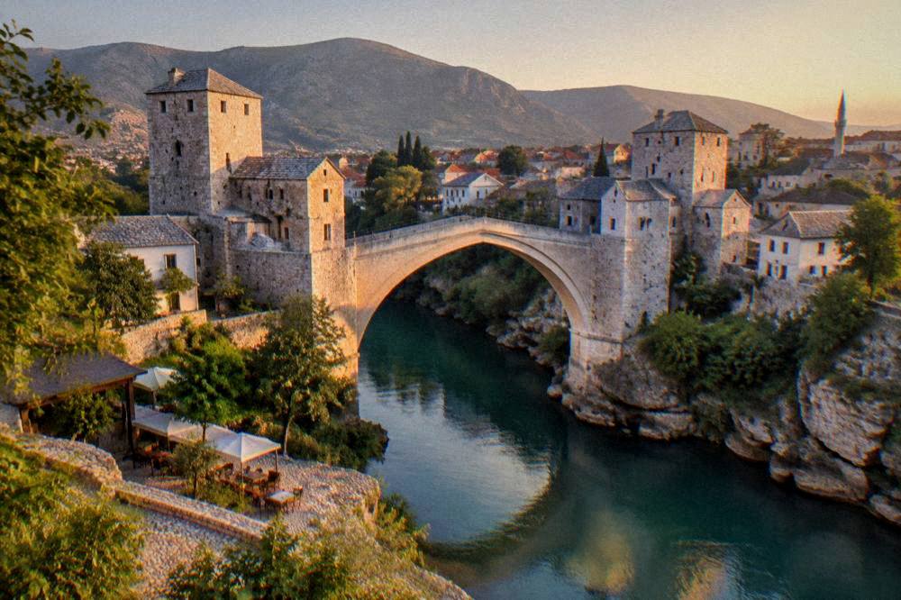Evening light on the Old Bridge and the riverbank buildings of Mostar