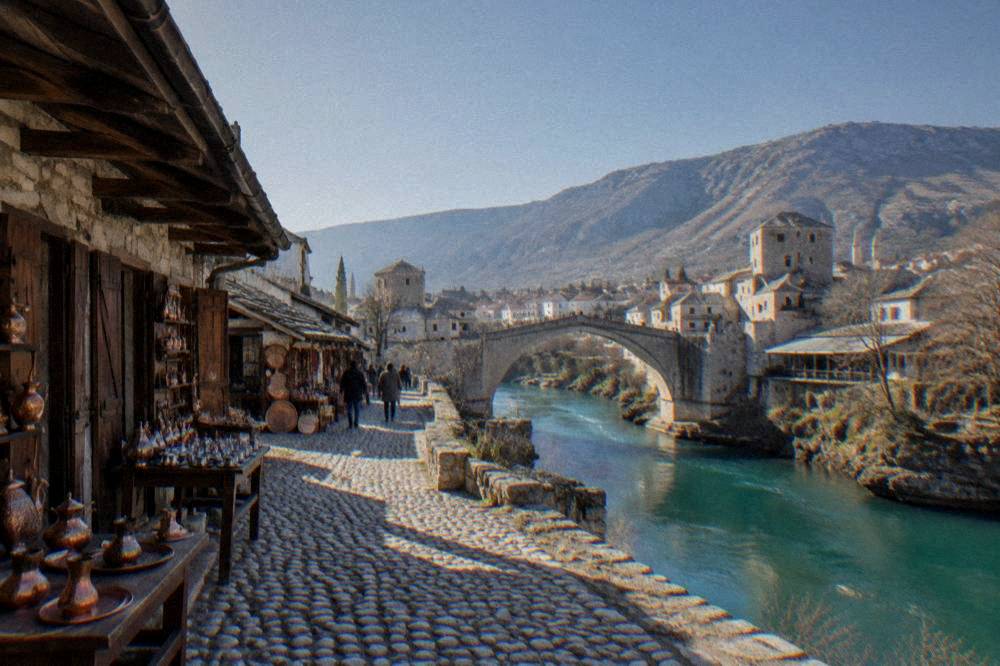 A stone bridge arch over a turquoise river in a Balkan old town