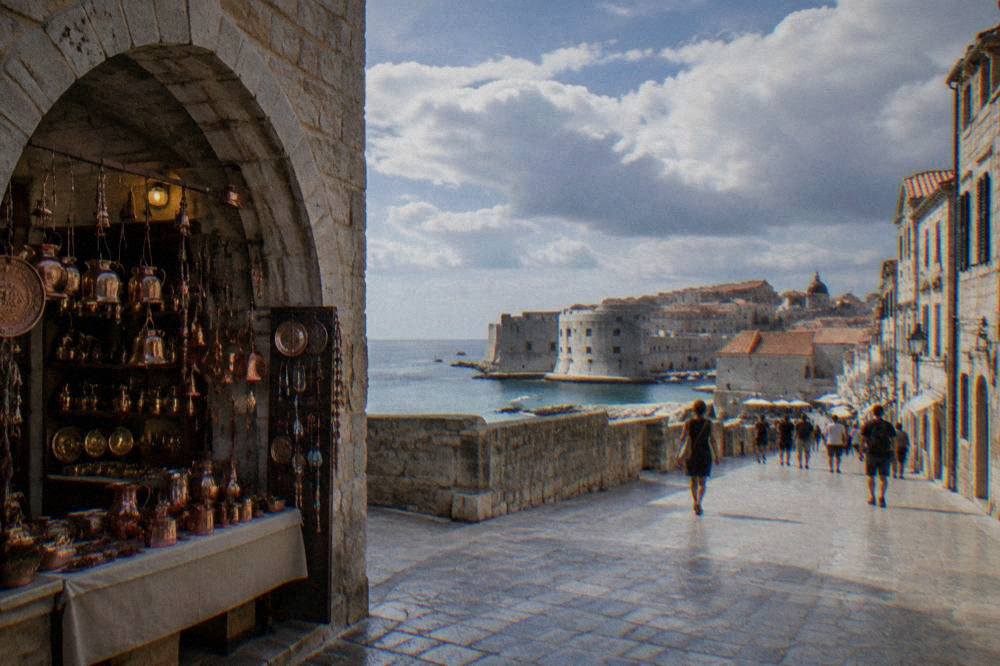 A market stall with copper souvenirs and handicrafts under a stone archway