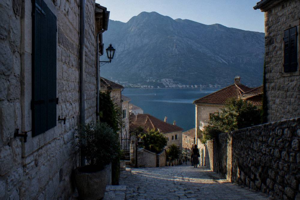 An early morning street with stone buildings and long shadows in a small Balkan town