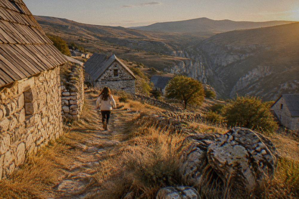 A narrow lane between old stone farmhouses on a highland plateau