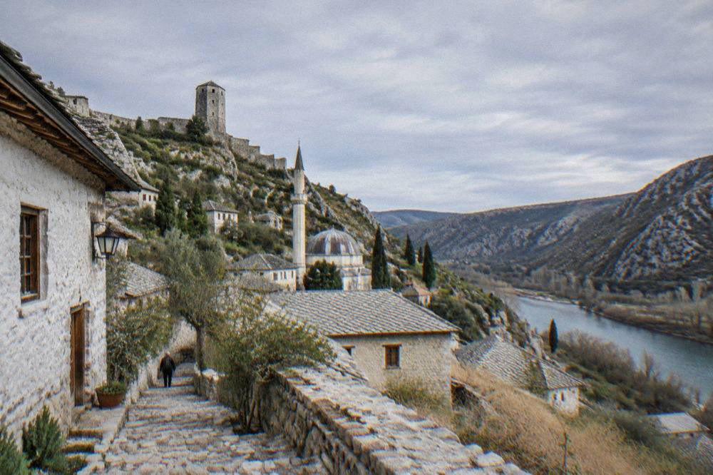 Narrow stone steps between whitewashed and honey-coloured houses in Počitelj village