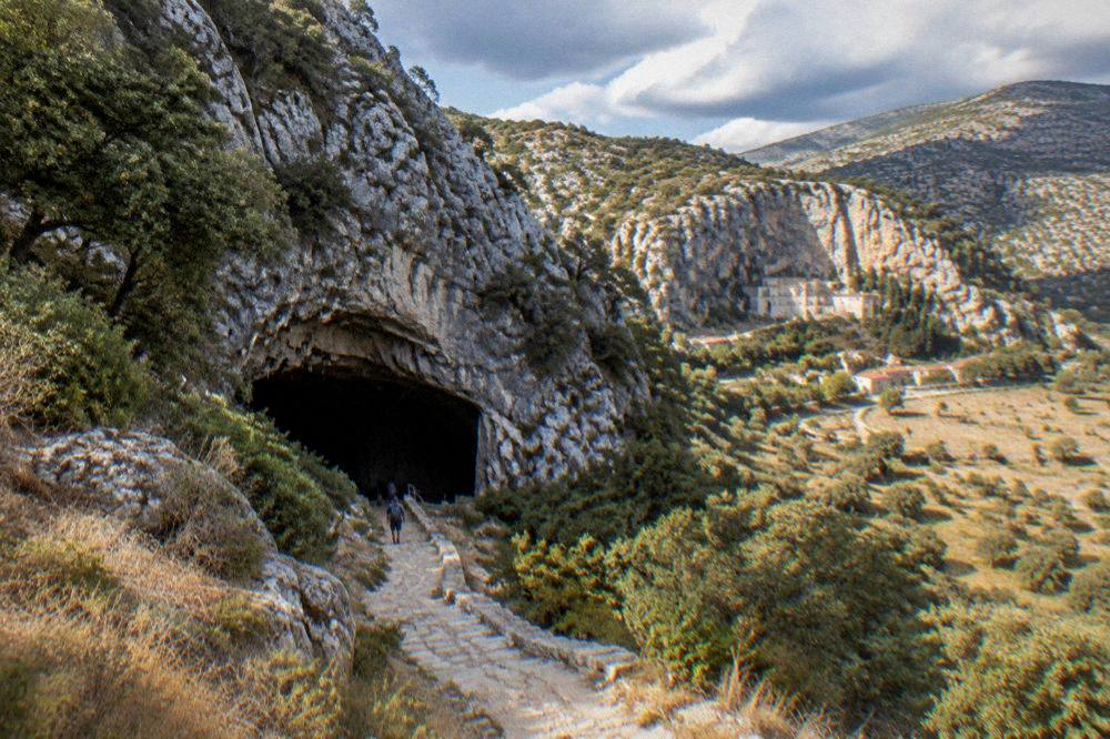 The village of Zavala below pale cliffs with monastery buildings set into the rock face