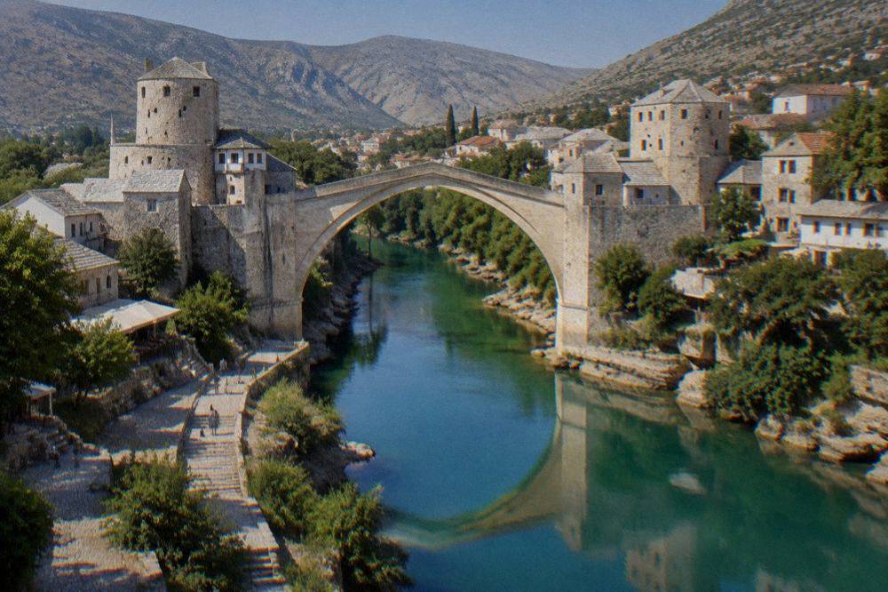 The illuminated arch of the Old Bridge reflected in the Neretva river at blue hour