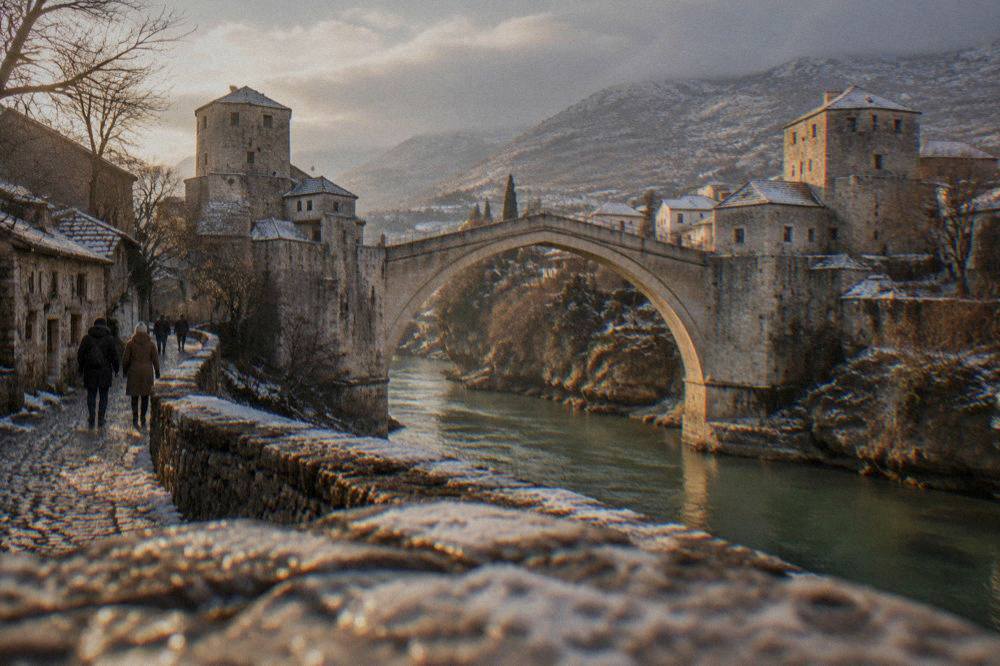 A quiet snow-dusted lane near the Old Bridge in Mostar on a winter evening