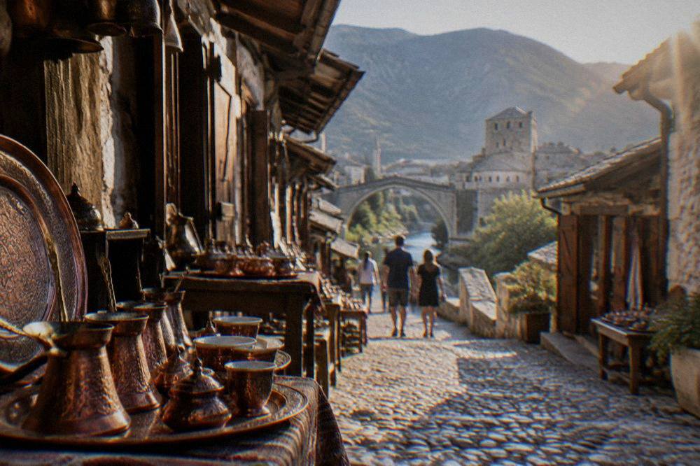 A walled Adriatic town at the edge of a blue bay with mountains rising behind it