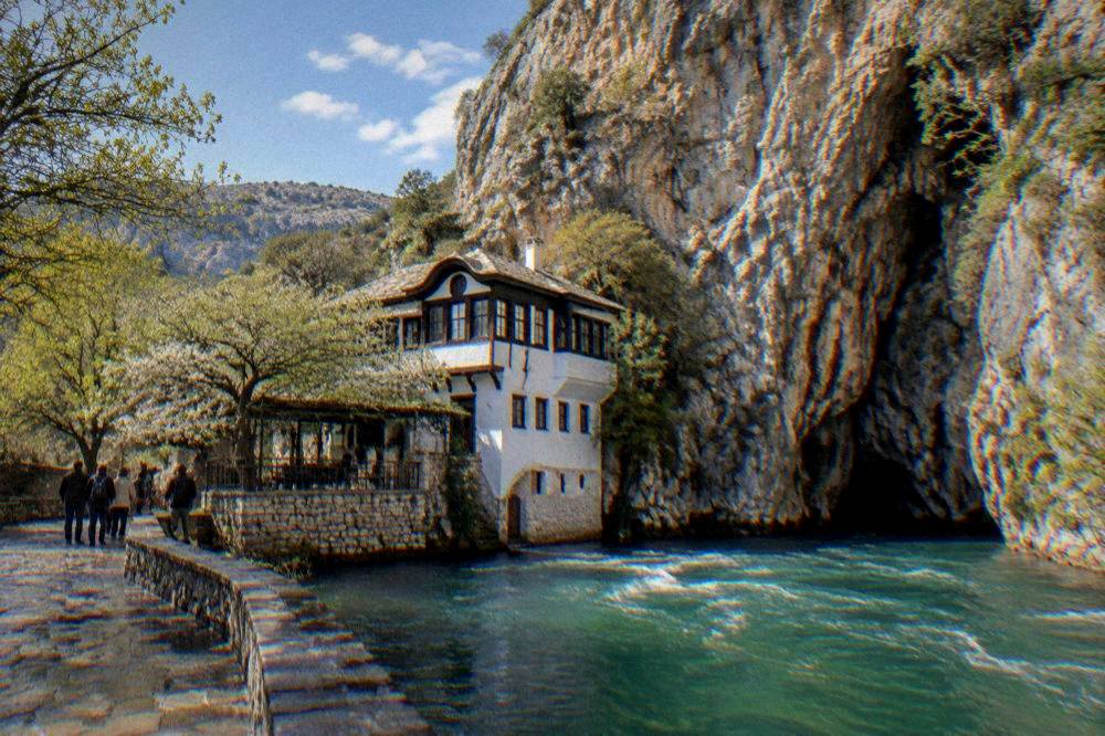The Blagaj tekke beside the Buna spring under a tall cliff face