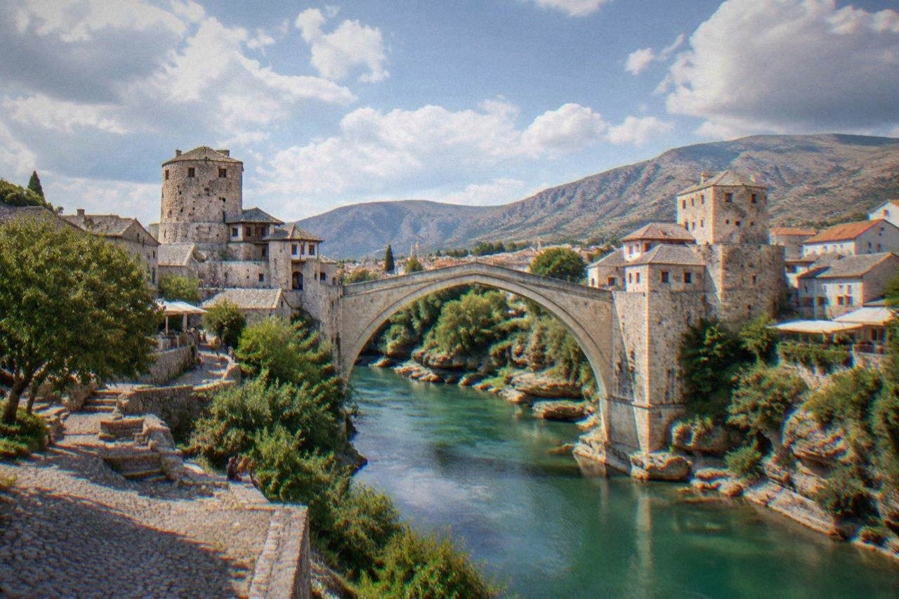 The stone arch of Stari Most crossing the green Neretva river in Mostar