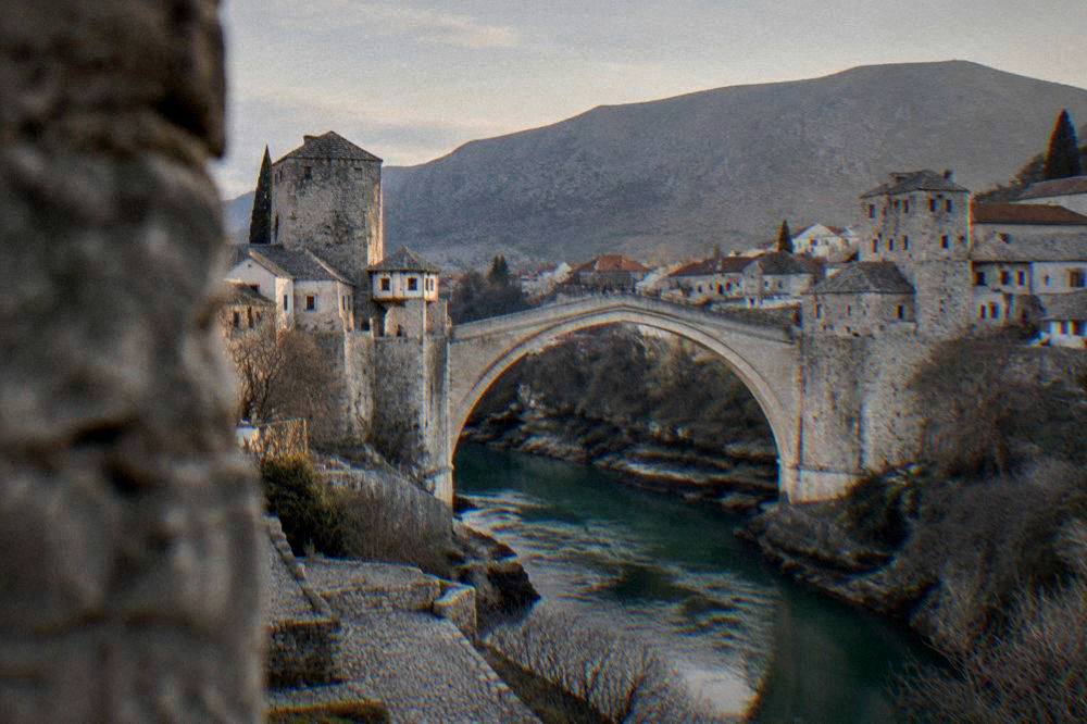 Clearing skies over the Old Bridge and the Neretva river at dusk in Mostar