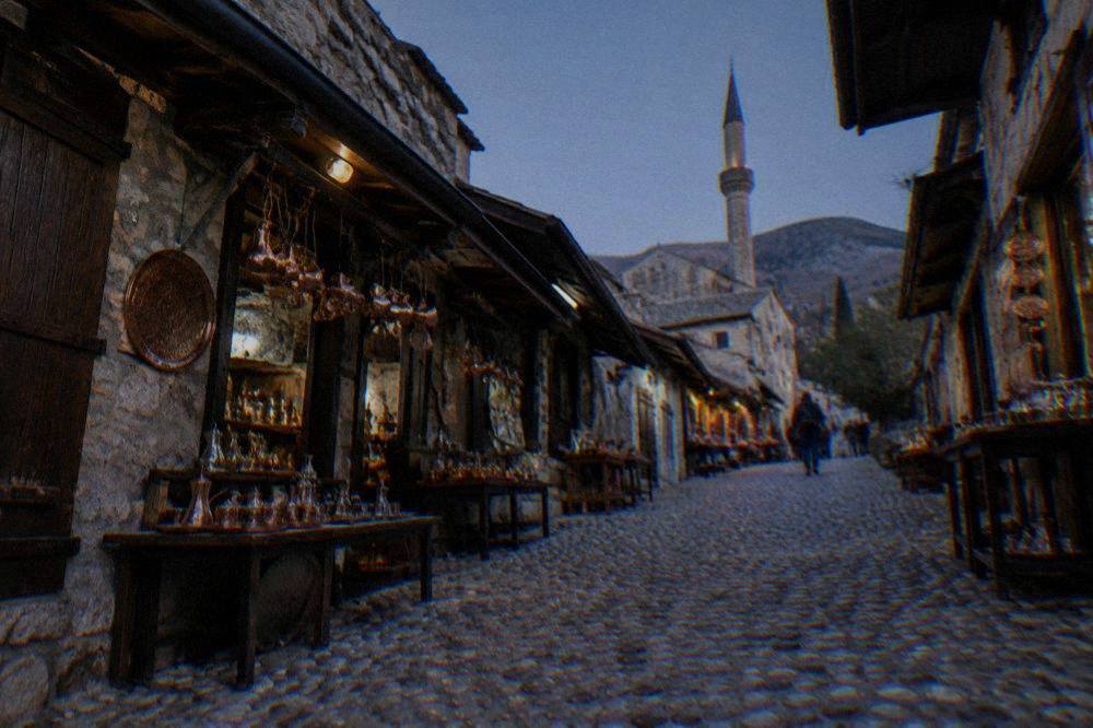 Cobbled bazaar street with stone shops and hanging copperware in the Mostar Old Town