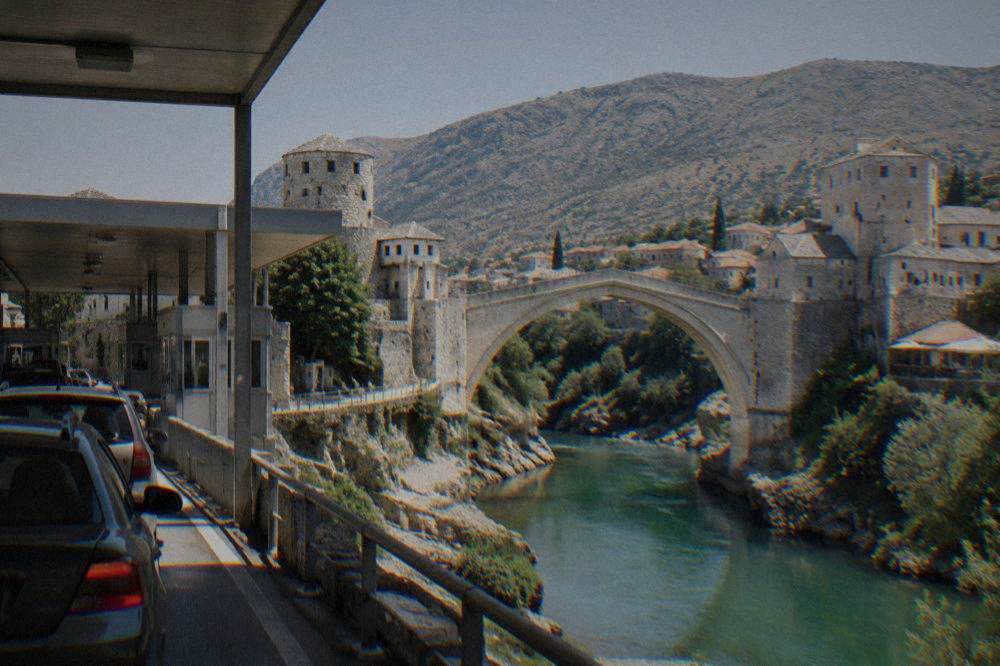 Border checkpoint booths with cars queuing between Croatia and Bosnia and Herzegovina