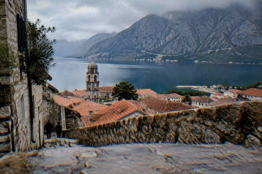 Bay of Kotor with steep mountains rising directly from the water and a small walled town on the shore