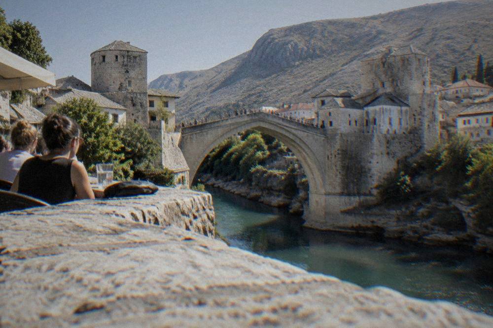 Crowds watching a diver leap from the Old Bridge into the Neretva river below