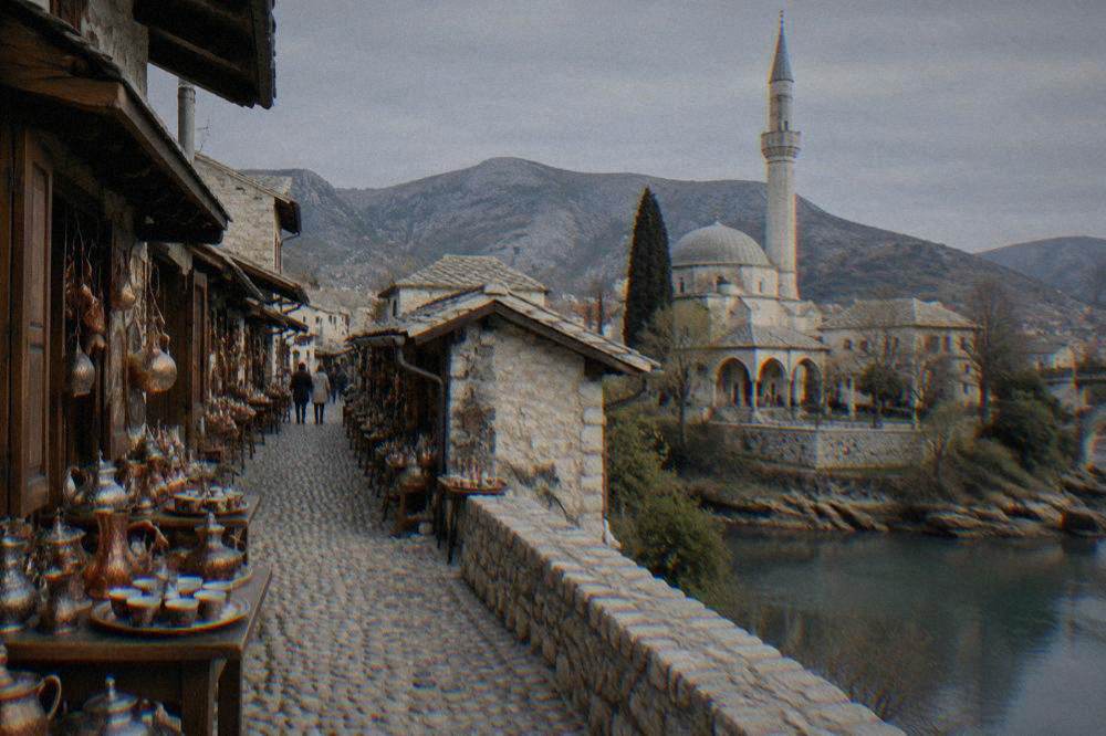 Stone minaret and courtyard of an Ottoman mosque beside the Neretva river in Mostar