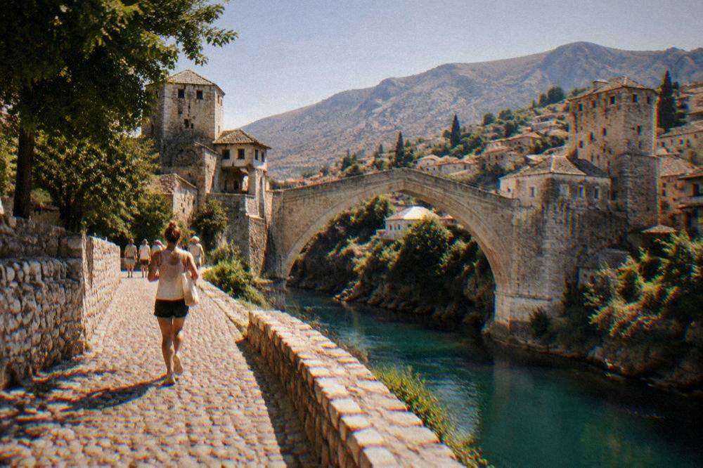 The Old Bridge and the hillside houses of Mostar under a clear summer sky