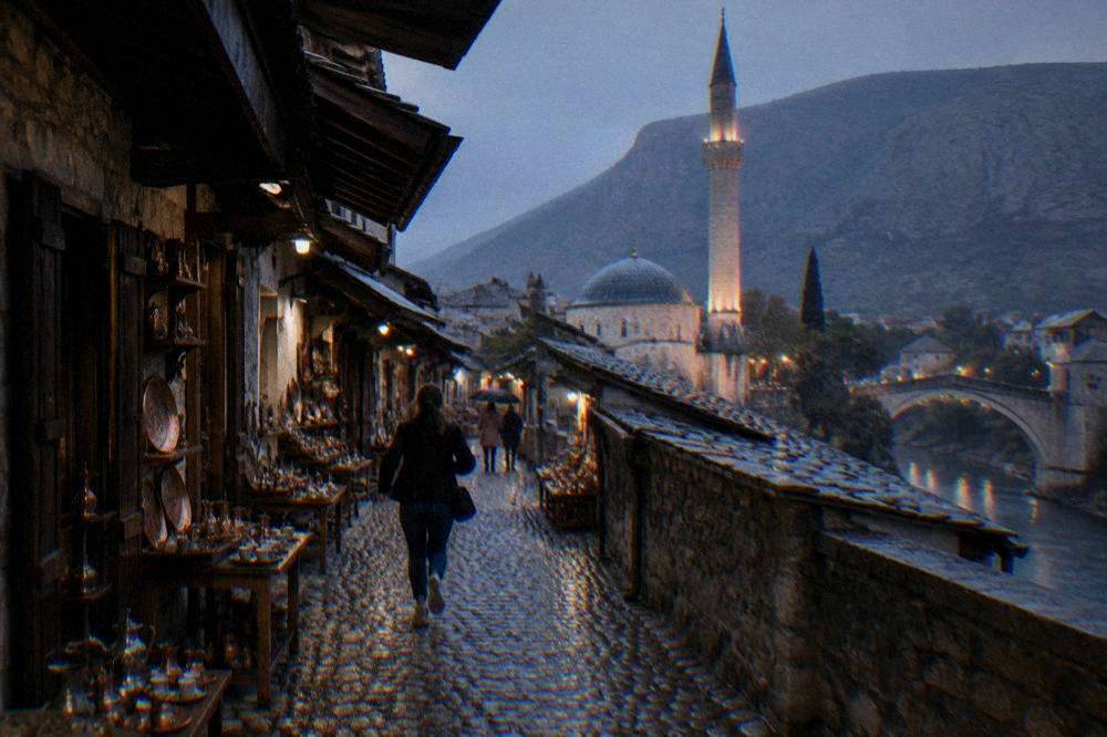 Rain running down the stone minaret and roof of the riverside mosque in Mostar old town