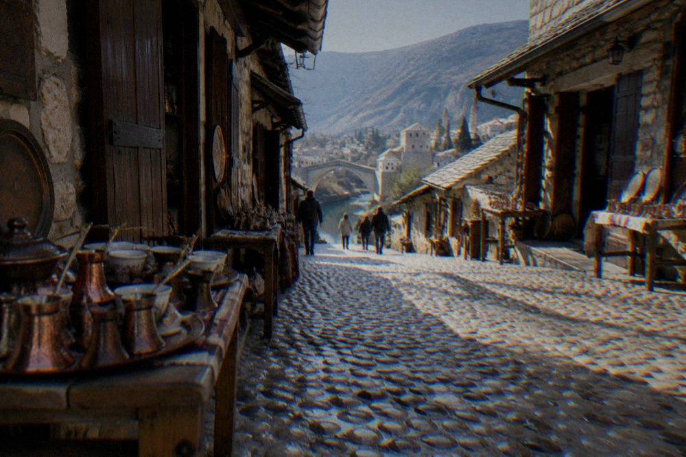 A rainy street in central Mostar with reflected lights on wet pavement in the evening