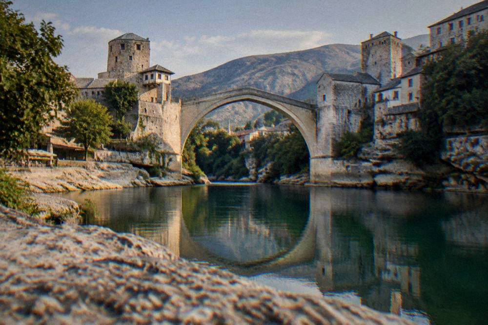 The Old Bridge reflected in the calm Neretva river at the end of the day