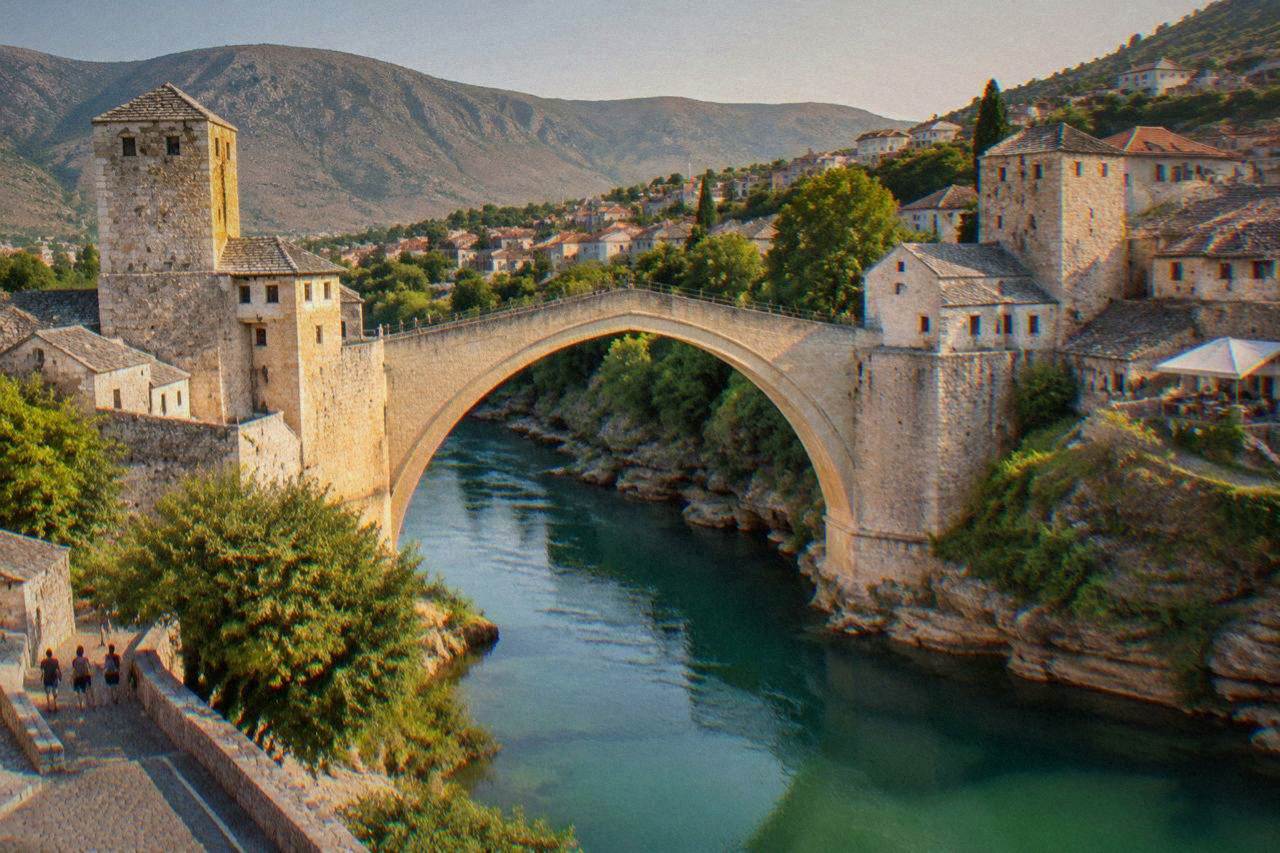 The Old Bridge arching over the green Neretva river at golden hour in Mostar